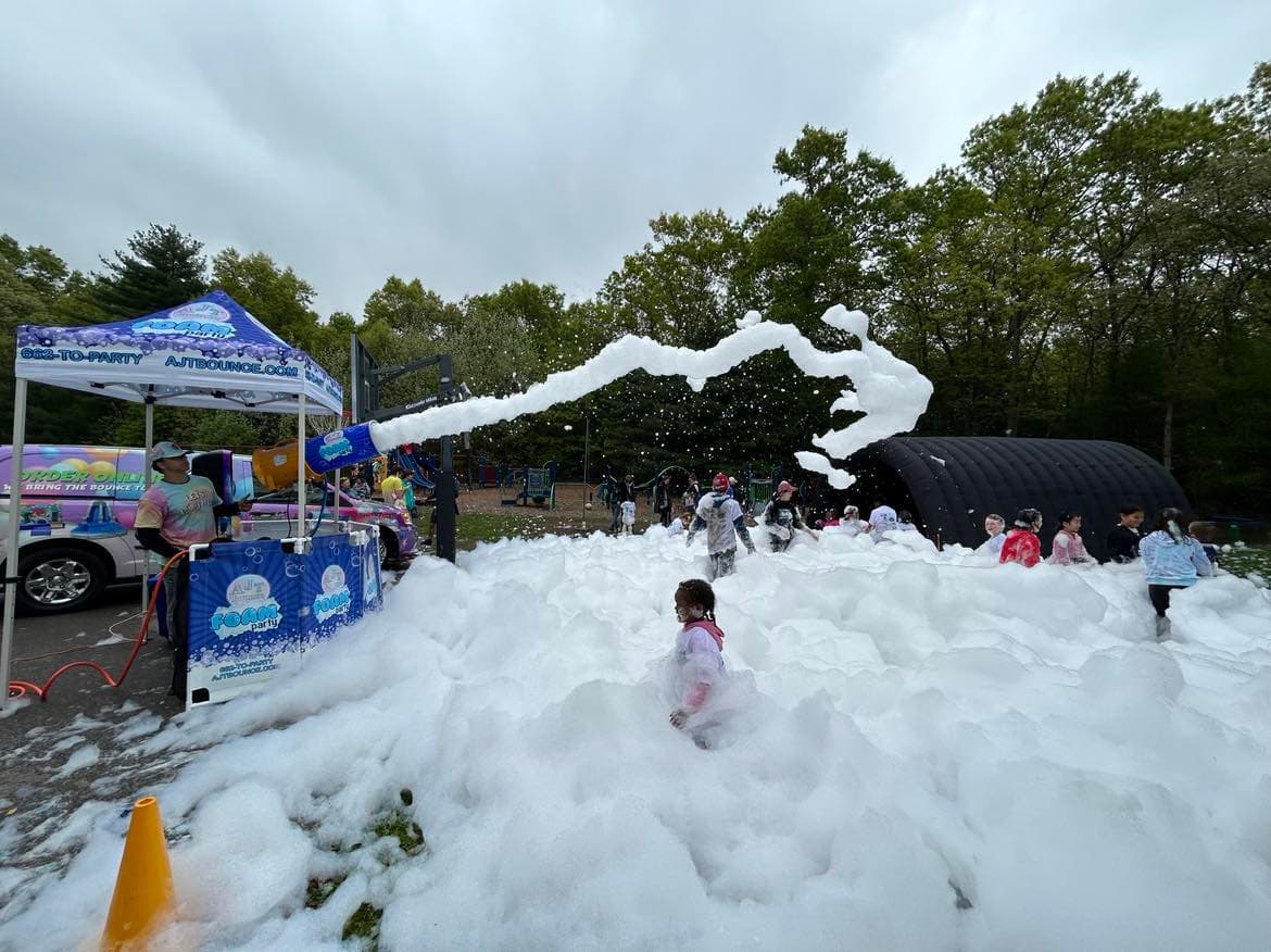 Kids playing in a mountain of foam at an AJT Bounce foam party
